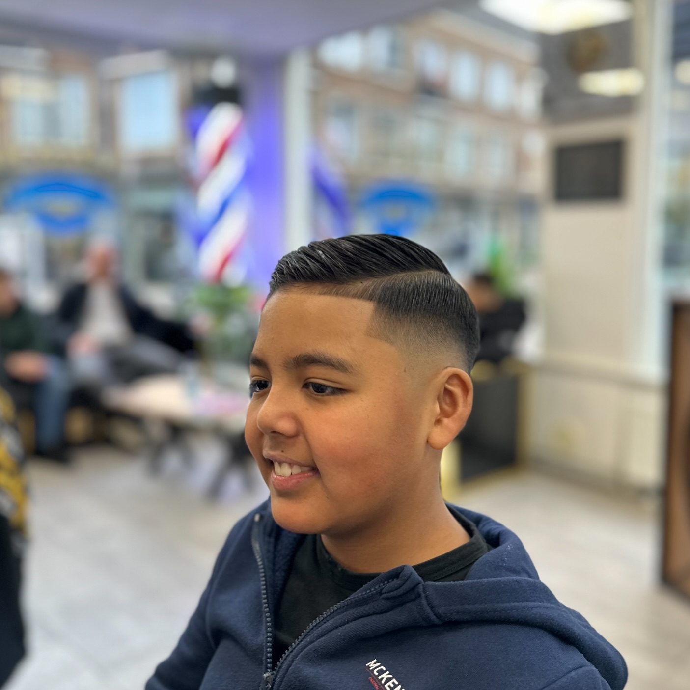 Jonge klant met een zijscheiding en strakke fade
